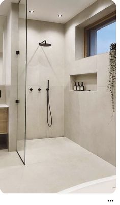 a bathroom with a shower, sink and mirror in it's center wall is shown