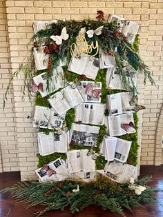 a wall covered in photos and greenery next to a fireplace