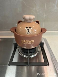 a brown bear pot on top of a stove