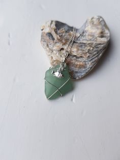 "Here's a beautiful handmade sea glass necklace The diamond shaped sea glass is seafoam in colour The sea glass is approx 2.2cm long, 1.2cm wide and 0.3cm thick The sea glass is wrapped in sterling silver wire wrap and has a sterling silver fish charm The whole pendant is approx 3cm long and 1.2cm wide The pendant comes with a 16\" or 18\" sterling silver curb chain A beautiful unique & special gift to celebrate a birthday, an anniversary, mothers day, christmas, valentines day...or why not treat yourself! It comes in a pretty cotton bag and is posted 1st class recorded All sea pottery, sea glass, sea shells, driftwood  & pebbles that I use for my work have been found on Anglesey, in North Wales. Once I've found my pieces I enjoy taking them home & hand making them into something beautiful Sea Pottery, Sterling Silver Wire Wrap, Sea Glass Necklace, Jewellery Gift, Glass Necklace, Curb Chain, Wire Wrap, Cotton Bag, Silver Wire