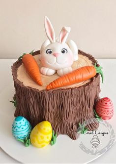 a cake decorated to look like a tree stump with an easter bunny in the center