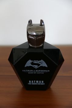 the batman logo is on top of a black trophy that sits on a wooden table