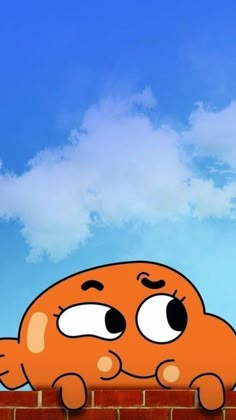 an orange cartoon character sitting on top of a brick wall with his eyes wide open