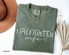 Are you looking for Christmas Firefighter Wife Shirt? We got you! ✅ ABOUT OUR Fire Department Comfort Color T-shirt  ▸ 100% ring-spun US cotton for long-lasting comfort.  ▸  The garment is sewn around the finished edges with double stitching, making it long-lasting ▸  The garment is dyed after it's been constructed, giving it a soft color and texture ▸ Printed and shipped from the USA ✅ HOW TO ORDER your First Responder Shirt 1. Check our photos for sizing and color options. 📏 2. Choose your qu Firefighter Wife Shirt, Firefighter Mom, Photo Care, Firefighter Wife, Comfort Color, Favorite Shirts, Mom Shirts, Soft Colors, Firefighter