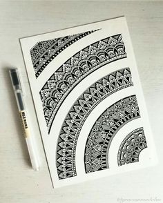 a pen is sitting on top of a notebook with an intricately designed design in black and white