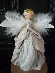 an angel doll with white feathers on it