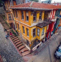 an aerial view of some old buildings in the middle of a street with cars parked on the side