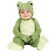 a baby in a frog costume sitting on the ground