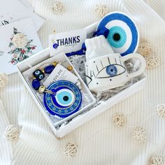 an open box with some items in it on a white blanket next to other things