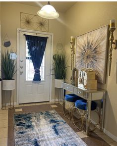 a living room filled with furniture and decor on top of a rug next to a door