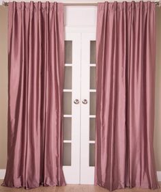 a pink curtain hanging on the side of a white door