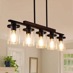 a light fixture with five mason jars hanging from it