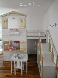 a doll house with stairs leading up to the loft bed and table in front of it