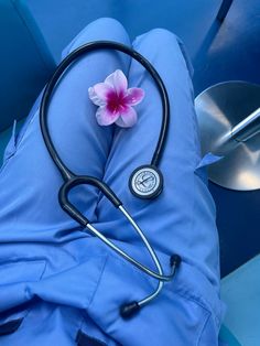 a stethoscope laying on top of a pillow with a flower in it