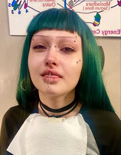 a woman with green hair and piercings on her nose is posing for the camera