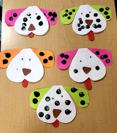 four paper dog masks on a table with black and white dots in the shape of dogs