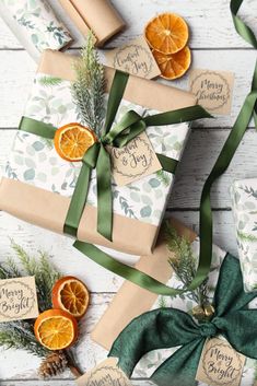 presents wrapped in brown paper with green ribbon and orange slices on them, surrounded by greenery