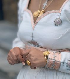 a close up of a person wearing a dress and holding something in their hand with both hands