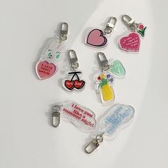 a bunch of different shaped key chains on a white surface with words and symbols attached to them