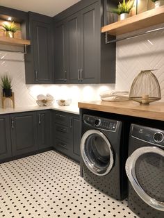 a washer and dryer sitting in a kitchen next to some shelves with plants