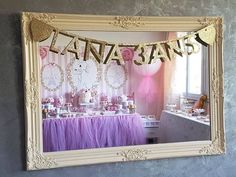 a fancy party with pink and gold decorations on the wall, including a cake table