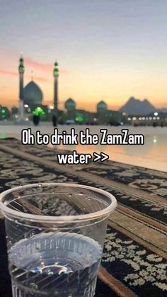 a plastic cup sitting on top of a rug next to a river with the words oh to drink the zanzann water