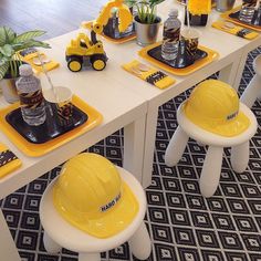 a table with construction themed place mats and yellow hard hats on it's legs