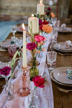 the table is set with flowers and candles