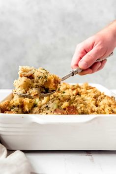 a person scooping food out of a casserole dish