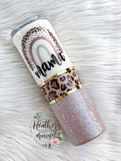 the unicorn glitter tumbler is sitting on top of a white fur covered surface, and has