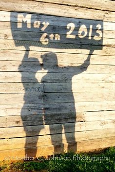 the shadow of two people holding up a sign