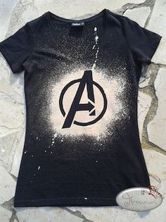 a black shirt with the avengers logo on it and a white football next to it