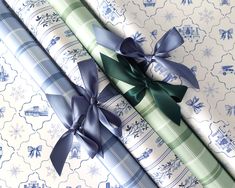 two wrapped presents sitting next to each other on top of a blue and green wrapping paper