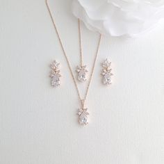 three pieces of jewelry sitting on top of a white flower