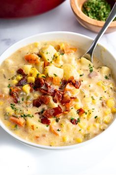 a white bowl filled with soup next to a red pot