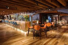 a restaurant with wooden floors and colorful chairs