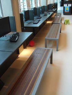 a row of computers sitting on top of desks next to each other in a room