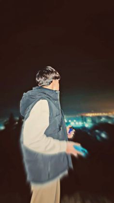 a man standing on top of a hill at night