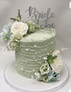 a green wedding cake with white flowers on top