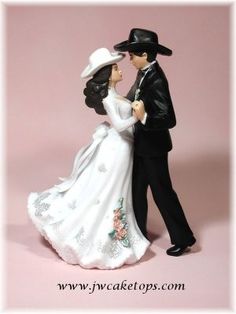 a bride and groom figurine on a pink background