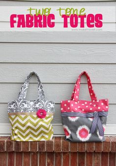 two fabric totes sitting on top of a brick wall next to a white door