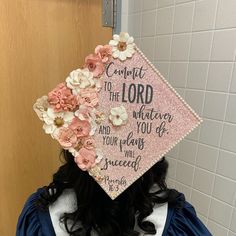 a woman wearing a pink graduation cap with flowers on it's head and the words comfort to the lord written in cursive