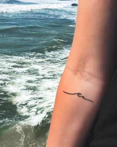 a woman's arm with a small tattoo on her left wrist and the words uttoriska written in cursive writing