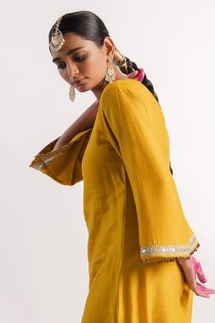 Mustard slub silk A-line kurta with sequins hand embroidered placket and sleeve hems. Comes with straight pant.
Components: 2
Pattern: Hand embroidered
Type Of Work: Sequins
Neckline: Round
Sleeve Type: Flared Sleeves
Fabric: Slub silk
Color: Yellow
Other Details: 
Small coin detailing on kurta
Occasion: Puja - Aza Fashions A Line Kurta, Sequin Sleeve, Fashion App, Pant Set, Straight Pants, Set For Women, Flared Sleeves, Aza Fashion, Sleeve Type