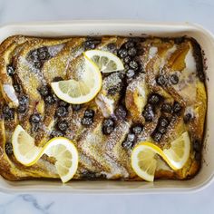 baked french toast with lemons and blueberries in a baking dish on a marble countertop