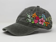 a gray hat with embroidered flowers on it