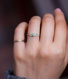 a woman's hand with two rings on it and one ring in the middle