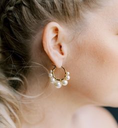 a close up of a person wearing some kind of earring with pearls on it