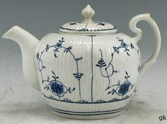 a blue and white tea pot with designs on it