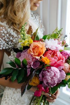 a woman holding a bouquet of flowers in her hands